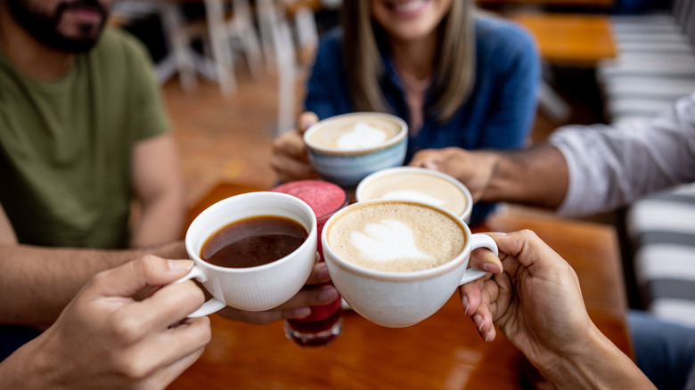 People cheersing with coffee mugs