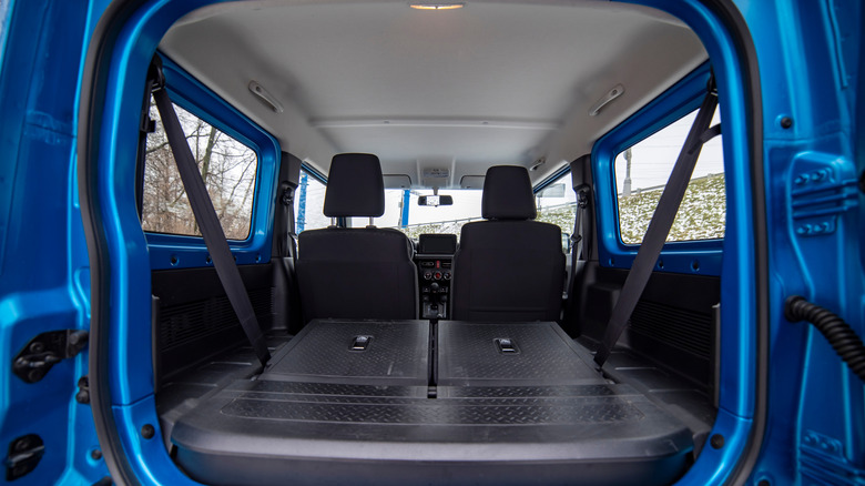Inside of an SUV with the seats folded flat.