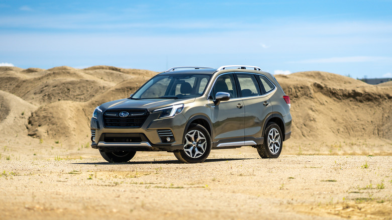 Modern SUV sitting off-road on a firm, sandy surface.