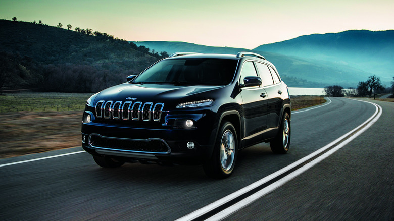A black 2014 Jeep Cherokee driving