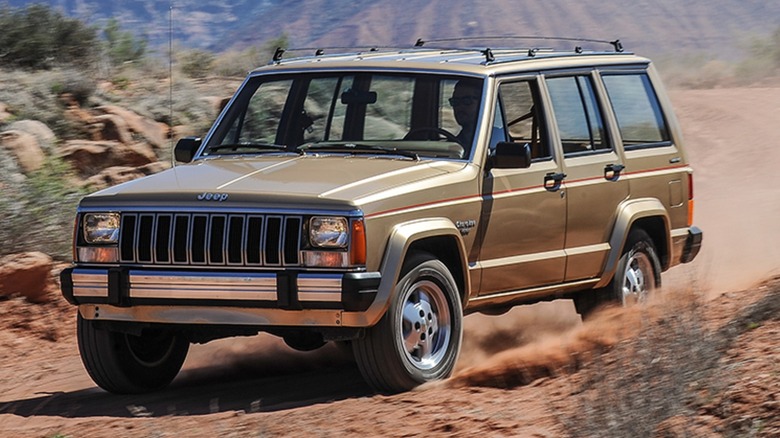 a Jeep Cherokee driving on a dirt road