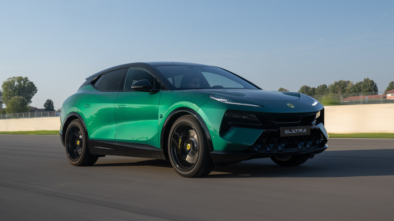A metallic green Lotus Eletre R SUV being driven on a track.