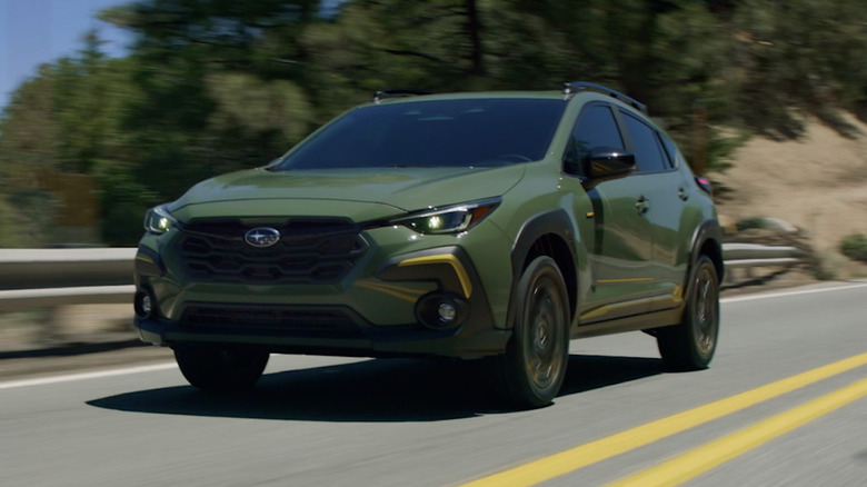 A green Subaru Outback on a highway
