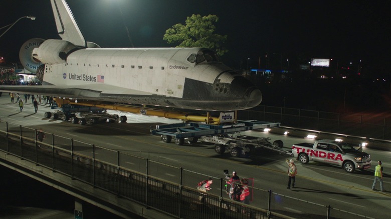 A Toyota Tundra pickup truck towing the NASA Space Shuttle Endeavour across a bridge in Los Angeles