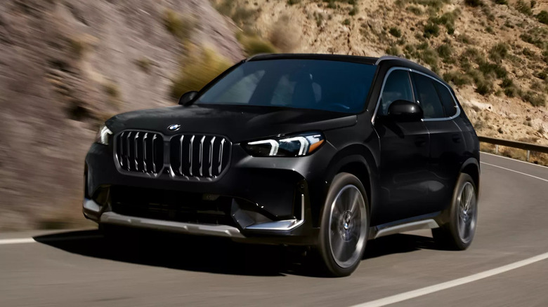 Black BMW X1 driving along a desert mountain road