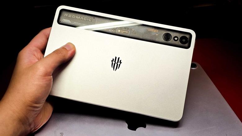 A person holding a RedMagic Astra tablet over an iPad Air M2