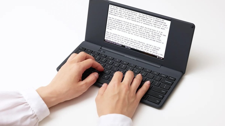 Hands on a pomera keyboard with a white background
