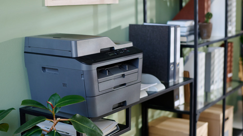 A printer on a table with its back to the wall