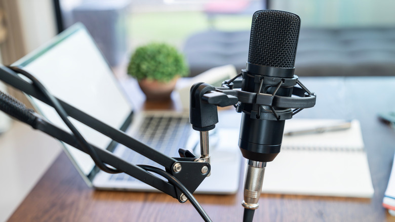 Podcast microphone and laptop in the background