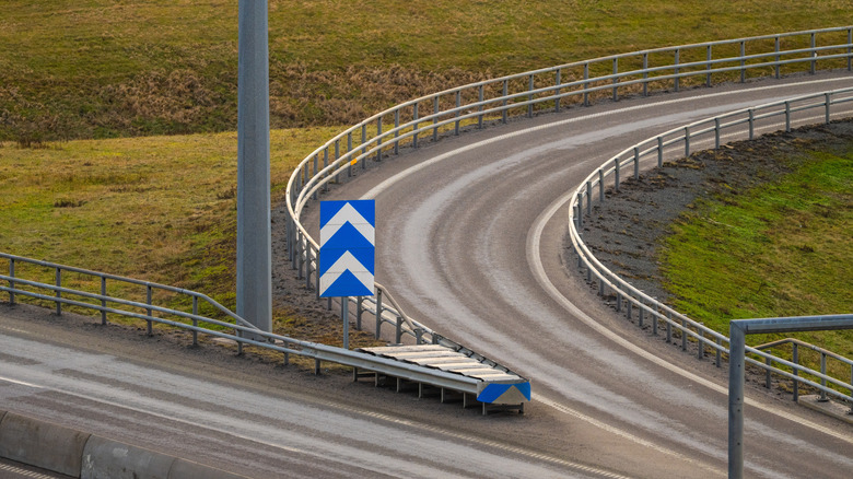 A curved highway exit ramp that rises up from the normal road level splitting off the main artery.