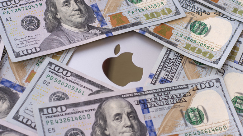 Macbook covered in $100 bills