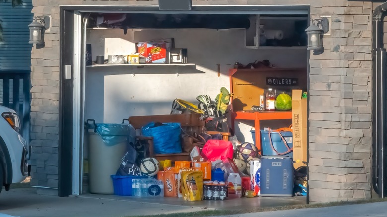 a garage with a lot of clutter viewed from outside.