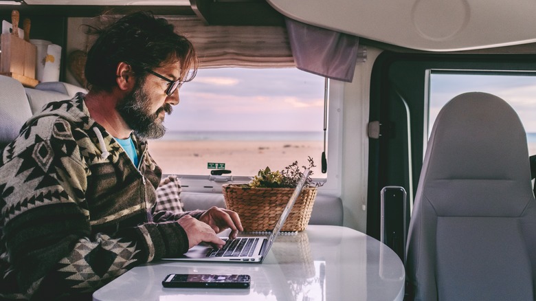 Person working on a laptop inside an RV