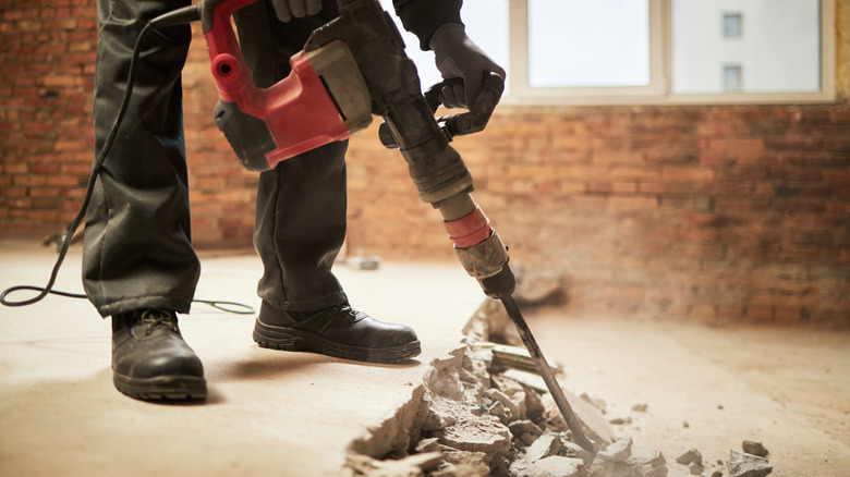 Man breaking up concrete with breaker