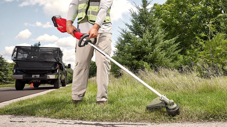 Person using Milwaukee Tools string trimmer
