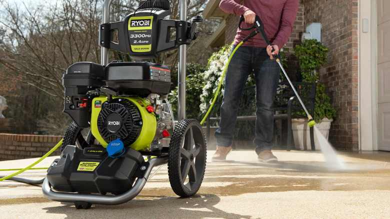 A person using a Ryobi gas-powered pressure washer.