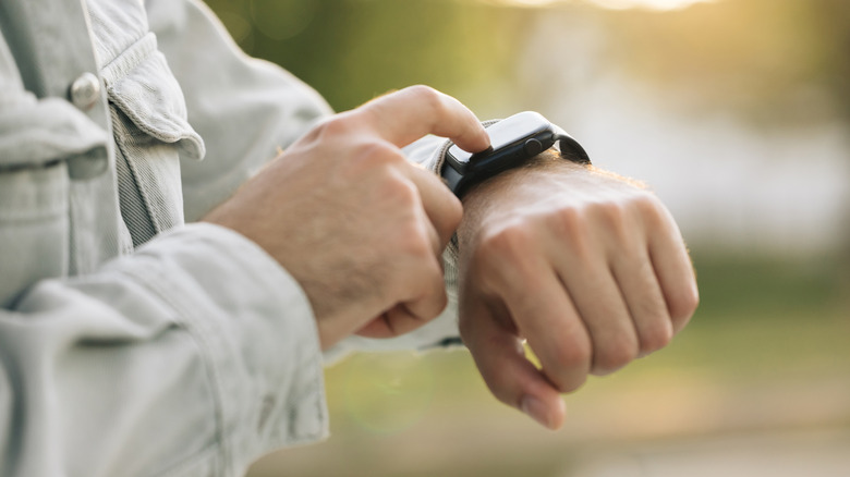 Man using Apple Watch outdoors