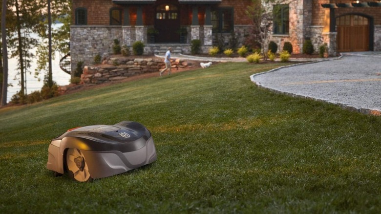 Husqvarna Automower 115H 4G Robotic lawn mower in use in front of a house