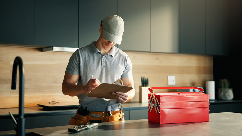 man writing on clip board