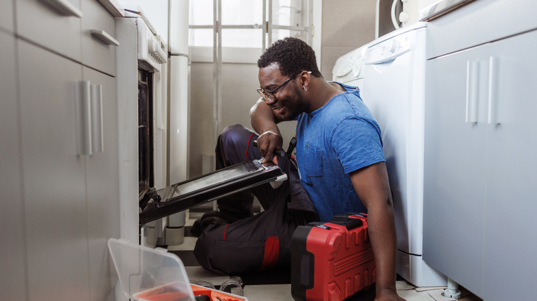 repairman with broken dishwasher