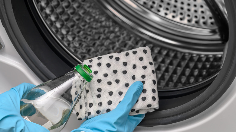 person cleaning inside washing machine