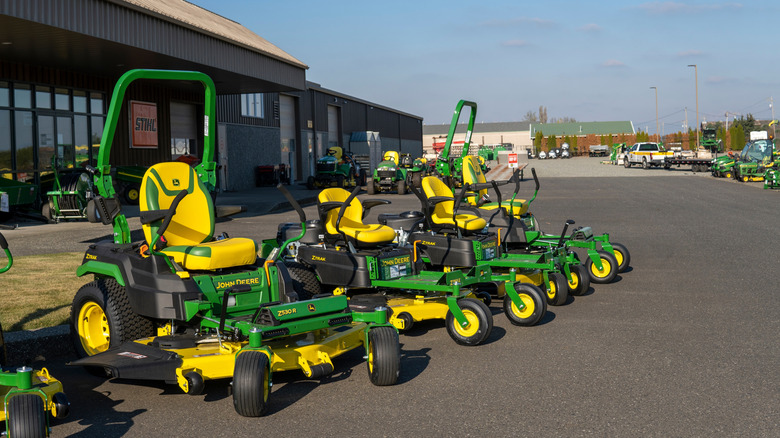 A row of John Deere zero-turn mowers on display.
