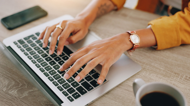 Person typing on laptop researching something.