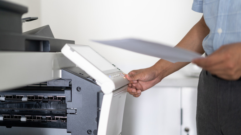 Man's hand on a printer button