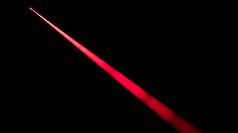 A red laser beam cutting through the dark