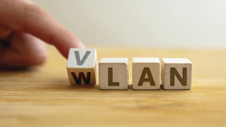 VLAN written on a series of wooden blocks with a hand turning the first one