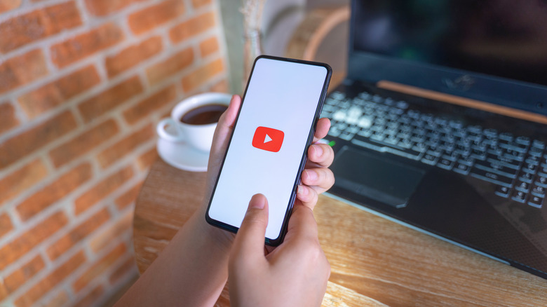 hand holding phone with YouTube logo