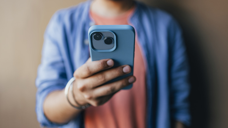 person holding out iPhone in blue case