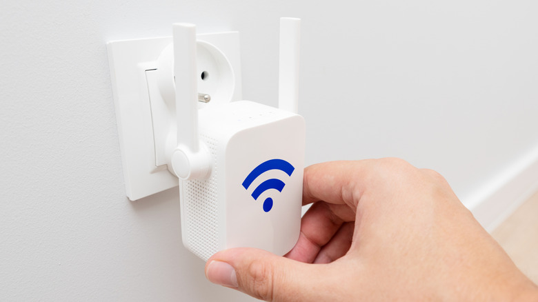 Person plugging in a Wi-Fi repeater