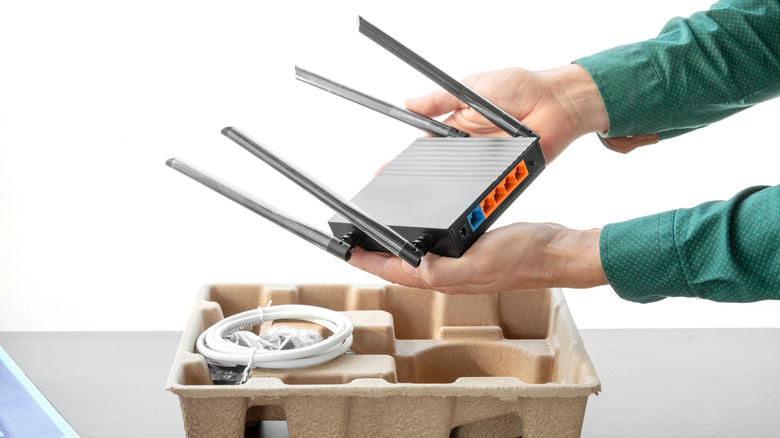 Person unboxing a Wi-Fi router