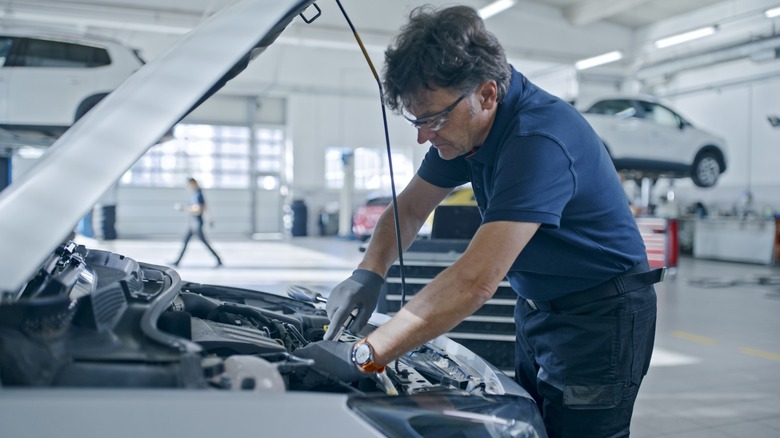 A man with gloves working on a car