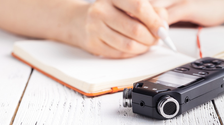 woman taking notes with handheld recorder