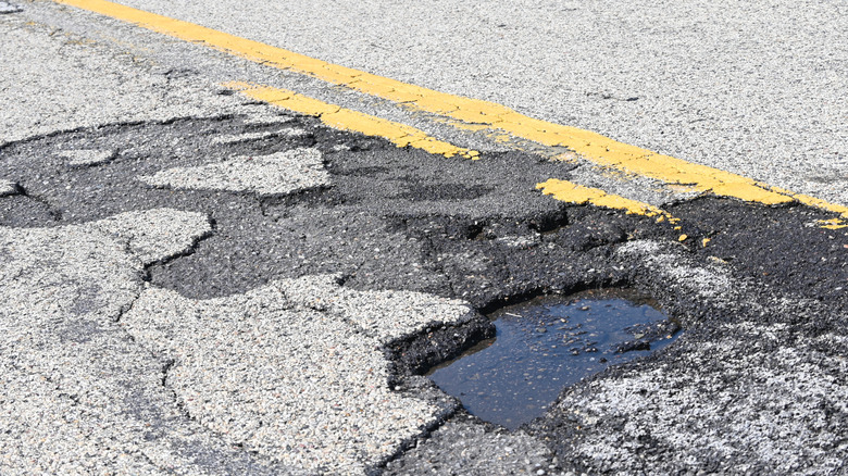 A damaged stretch of road with a pothole.