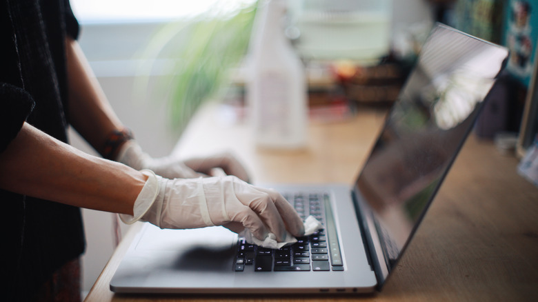 person wiping MacBook keyboard