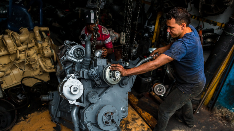 mechanic replacing engine