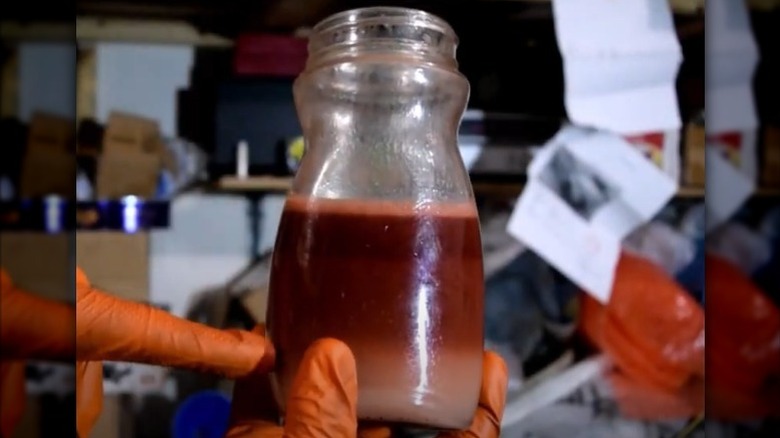 Redish mixture of water and transmission fluid in a container