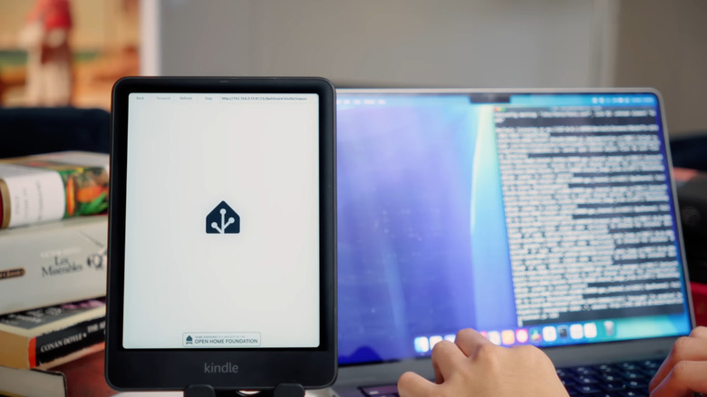 Person installing jailbreak on Kindle with MacBook in the background