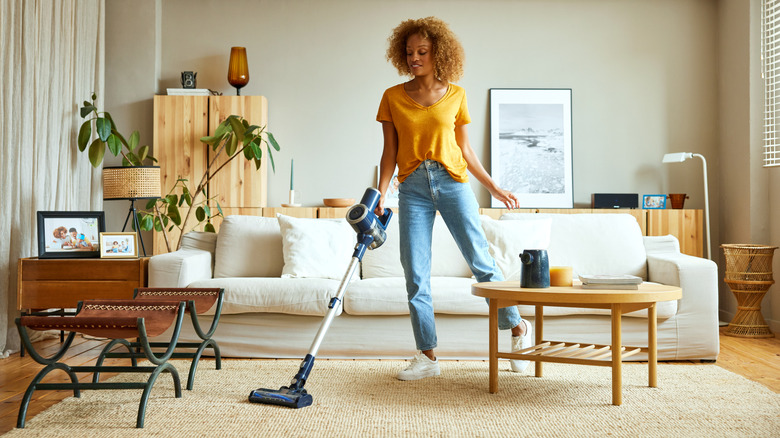 Woman cleaning her living room with a vacuum
