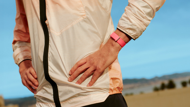 A man standing akimbo wearing the Google Fitbit air