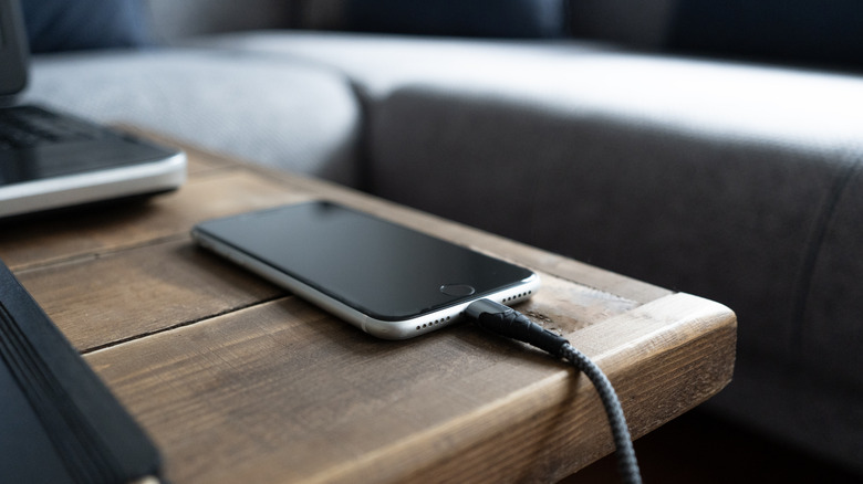 Smartphone charging on a wood table