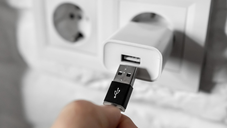 person plugging cable into a charging brick