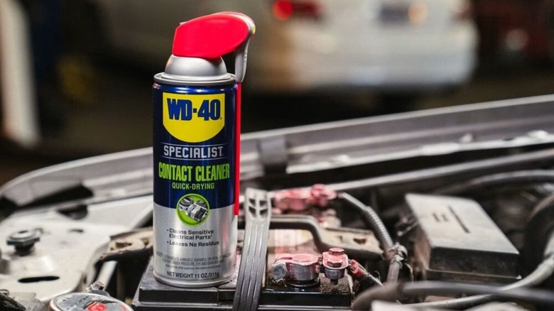 A can of WD-40 Contact Cleaner on top of a car engine