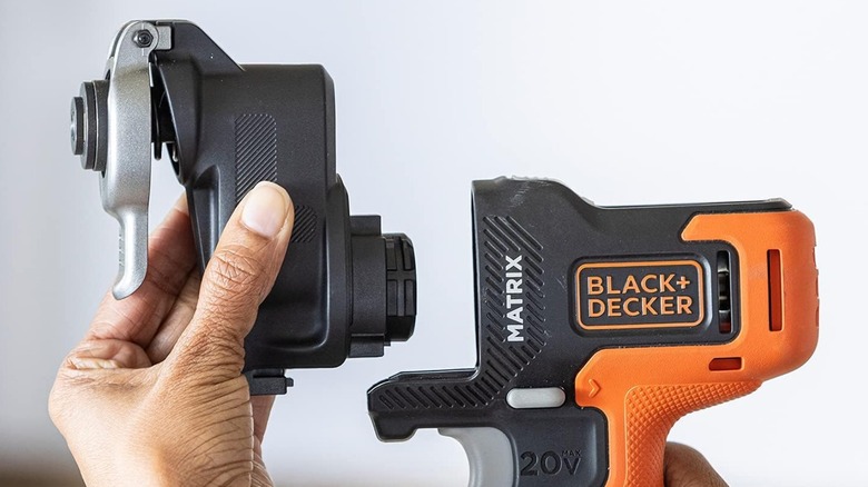 Person placing Black and Decker Matrix Oscillating tool attachment on power base