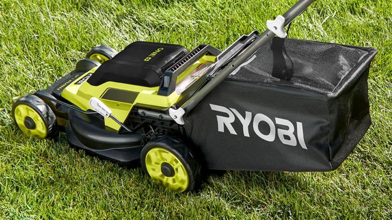 A Ryobi lawn mower on grass.