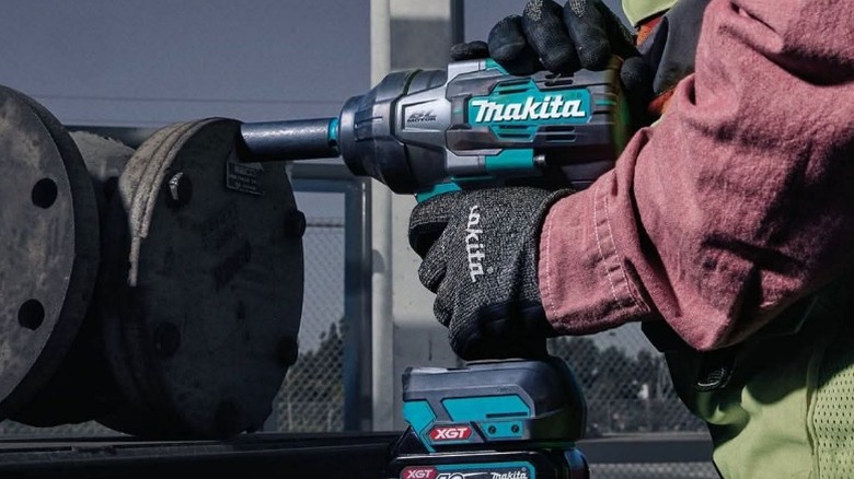 Person removing bolt with Makita impact wrench