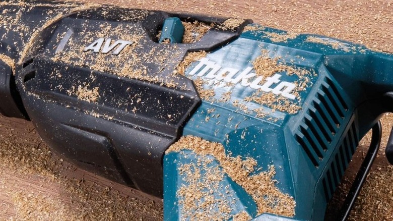 Close up of reciprocating saw on bench covered in sawdust